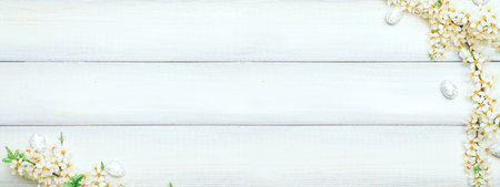 Easter eggs background. May flowers, white happy easter egg on wooden spring background. Easter card banner. Flat lay.の写真素材