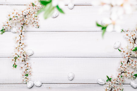 Easter spring background. Sakura flower, white happy easter egg on wooden spring background. Easter wallpaper. Spring holiday concept.の写真素材