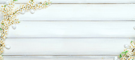 Easter white background. Spring flower border, white happy easter egg on wooden spring background. Easter card. Flat lay.の写真素材
