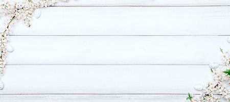 Easter background wood. Sakura blossom flower, white happy easter eggs on wood spring background. Easter design banner. Top view. Flat lay.の写真素材
