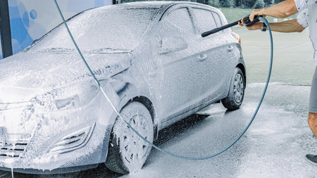 Car wash. Car cleaning foam soap bubbles. Spray water vehicle shine wet.の写真素材