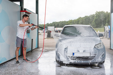 Vehicle cleaning. Automobile car wash soap. Foam spray water exterior detailの写真素材