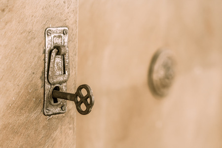 Close up old door with old lock and key. Old rusty key inside a keyhole. Selective focus on keyの写真素材