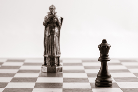 Classic black queen and the same piece in the form of medieval figure on the background. Selective focus on classic pieceの写真素材