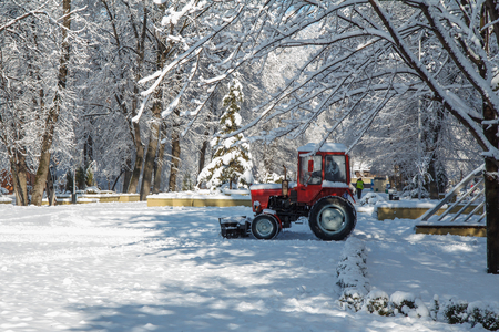 Municipal equipment  removing snow from the footpaths in the city park after snowfall. Winter timeの写真素材
