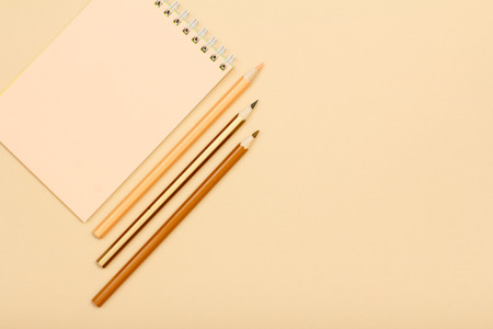 School supplies. Notebook and color pencils on beige background. Top view with copy space. Back to school concept. Pastel colorsの写真素材