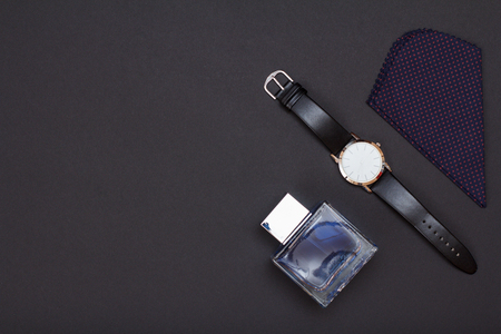 Watch with a black leather strap, cologne for men and handkerchief on gray background. Accessories for men. Top view with copy space.の写真素材