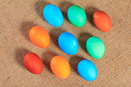 Painted eggs with sackcloth on the background. Traditional orthodox christian easter food. Top view.
