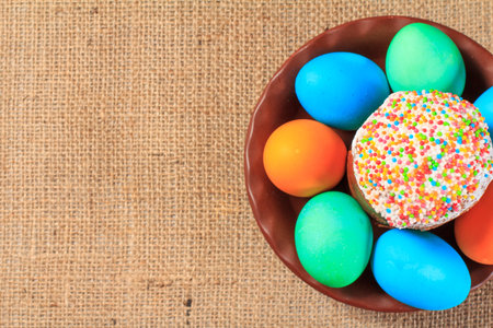 Easter cake and painted eggs on a plate with sackcloth