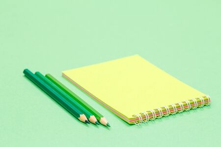 Color pencils and notebook on greenの写真素材