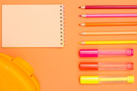 Color pencils, felt pens, notebook and lunch box on pink background. Top view with copy space. Back to school concept. School supplies. Pastel colorsの写真素材