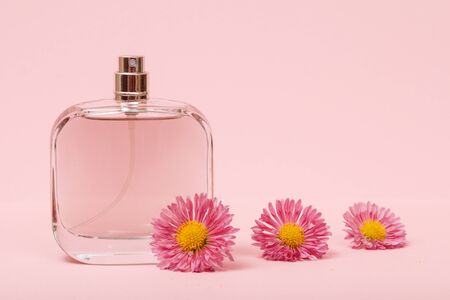 Bottle with women perfumes and buds of flowers in the pink background. Women products.の写真素材