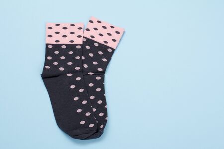 Pair of black and pink women socks on a blue background, Top view with copy space.の写真素材