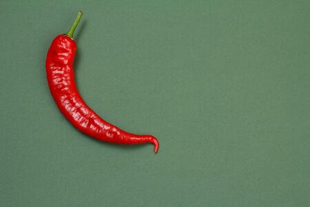 Close up fresh red hot pepper on green background. Top view with copy space.の写真素材
