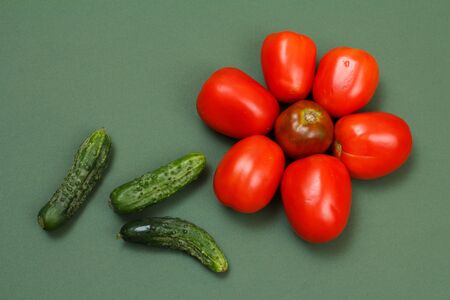 Top view of fresh tomatoes and cucumbers on green background. Vegetables on kitchen table. Top view.の写真素材