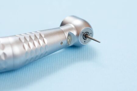 Head of high-speed dental handpiece. Dental instruments for dental treatment on blue background. Medical tools. Close-up view. Shallow depth of field.の写真素材