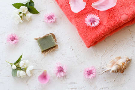 Towel, soap and flowers of jasmine and cornflower on a white background. Woman cosmetics and accessories. Top view.の写真素材