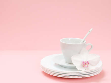 White plates, a saucer, a cup on the pink background. Washing and cleaning concept.の写真素材