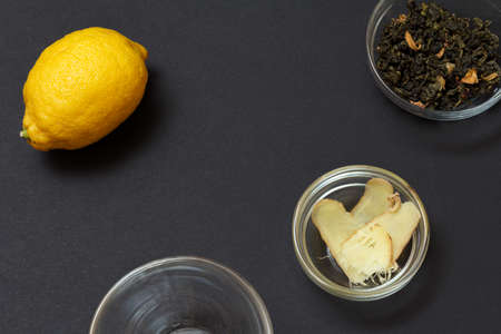 Health remedy foods for cold and flu relief with lemon, ginger and green tea on a black background. Top view. Foods That Boost the Immune System.の写真素材