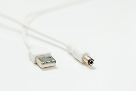 Close-up USB cable in white color on a white background. Shallow depth of field.