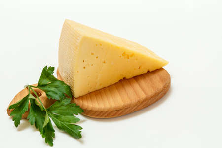 Break of cheese and fresh parsley on a wooden cutting board on the white backgroundの写真素材
