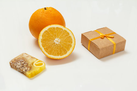 Cut orange with whole one, gift box and soap