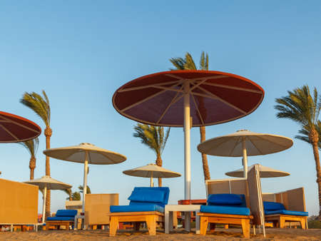 Beach with umbrellas and sunbeds against the blue sky.の写真素材