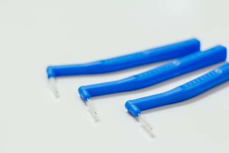 Close-up interdental brushes with blue grips on white background. Shallow depth of field.の写真素材
