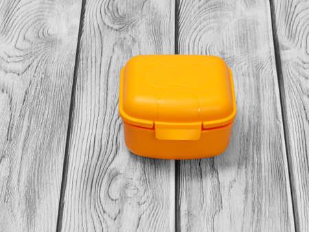 Yellow plastic lunch box on the gray wooden background. Top view.の写真素材