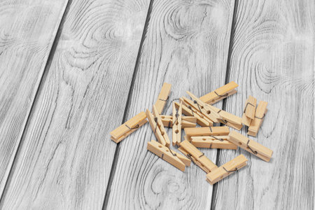 Heap of wooden clothes pins on the gray wooden background. Top view.の写真素材