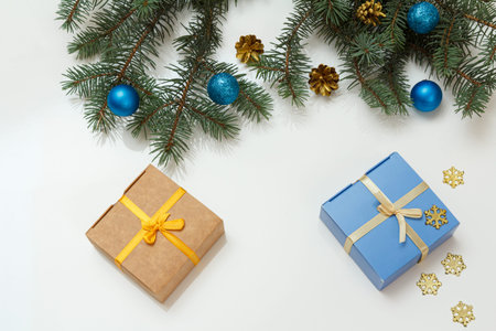 Christmas decoration. Gift boxes, fir tree branches with balls on the white background. Top view....