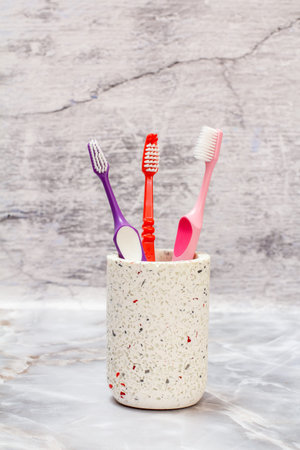 Stone can with toothbrushes on the gray background.