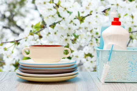 Bottles of dishwashing liquid, brush and plates on natural background.の写真素材