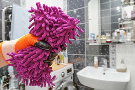 Mans hand in protective glove with the rag at the bathroom.の写真素材
