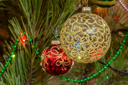 Close-up branch of the Christmas tree with toy balls and twinkling party lights. Christmas and New Year concept.の写真素材