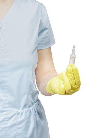 Female doctor in a latex glove holding an ampoule with medicine. Selective focus on the ampoule.の写真素材