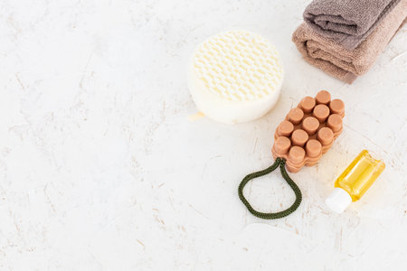 Products for facial and body care. Soft terry towels, a sponge, a soap and aroma oil on the white background. Spa and body care set. Top view with copy space.の写真素材