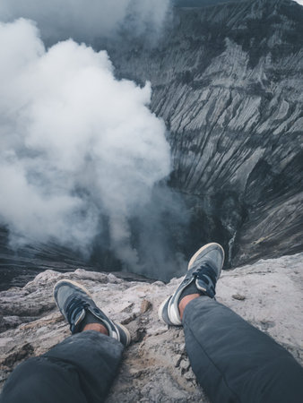 Feet on the edge of a volcano crater