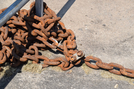 Rusty chain and anchor on the ground. Close up.