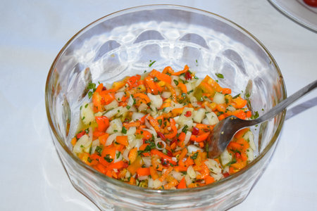 vegetable salad in a glass bowl on a white tableclothの写真素材