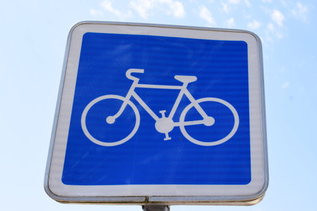 Bicycle road sign with blue sky background and white bicycle symbol.の写真素材