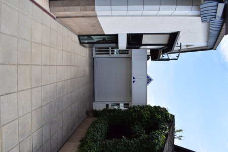 The front door of the modern building with blue sky in the backgroundの写真素材