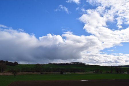 Clouds over the field in springtime, Eifel, Germanyの写真素材