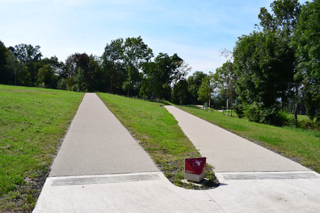 Suitable path in the park with green grass and blue sky.