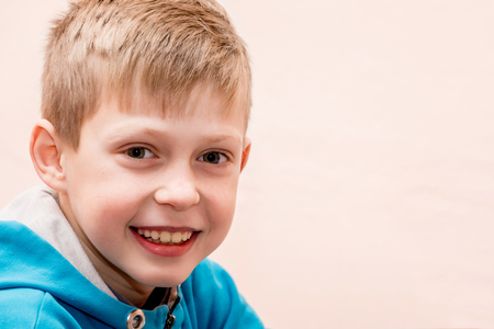 portrait of a smiling boy close up on a blurry pink background, a free space for the inscriptionの写真素材