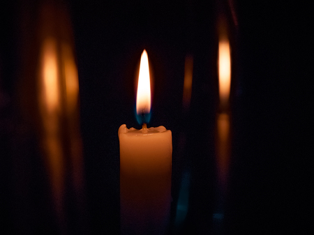 on a black background bright yellow candles, a holiday or a church burnの写真素材