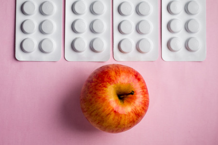 red apple on a tablets background, a natural product as an alternative to medicinesの写真素材