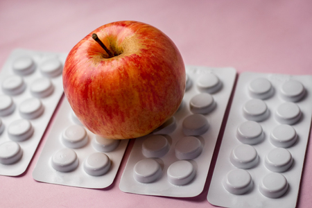 red apple on a tablets background, a natural product as an alternative to medicinesの写真素材