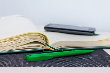 Notebook, pen and phone - means of recording information during   lecture at a school or college, universityの写真素材