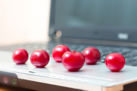 Ripe berries on a laptop. A break for food while working in the office. Useful and delicious food. Vitamins for healthの写真素材